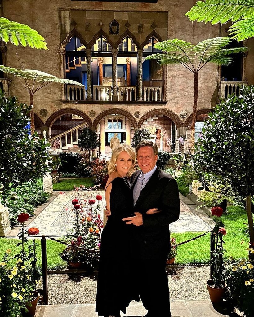 Jennifer and her husband smiling and holding each other in a villa like garden