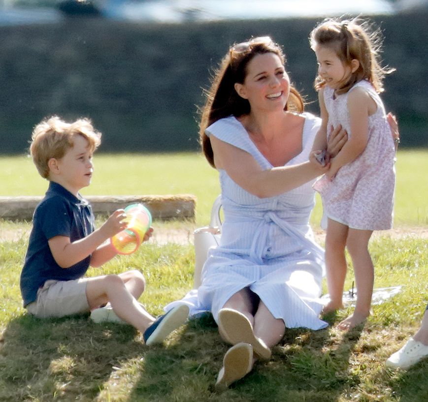 Kate cuddling Charlotte and sitting next to George at polo match, 2018
