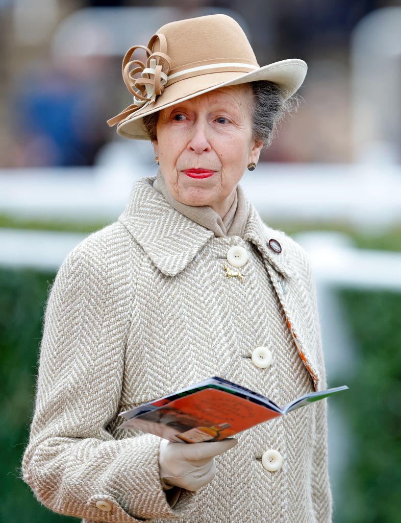Princess Anne holding booklet in neutral hat and coat