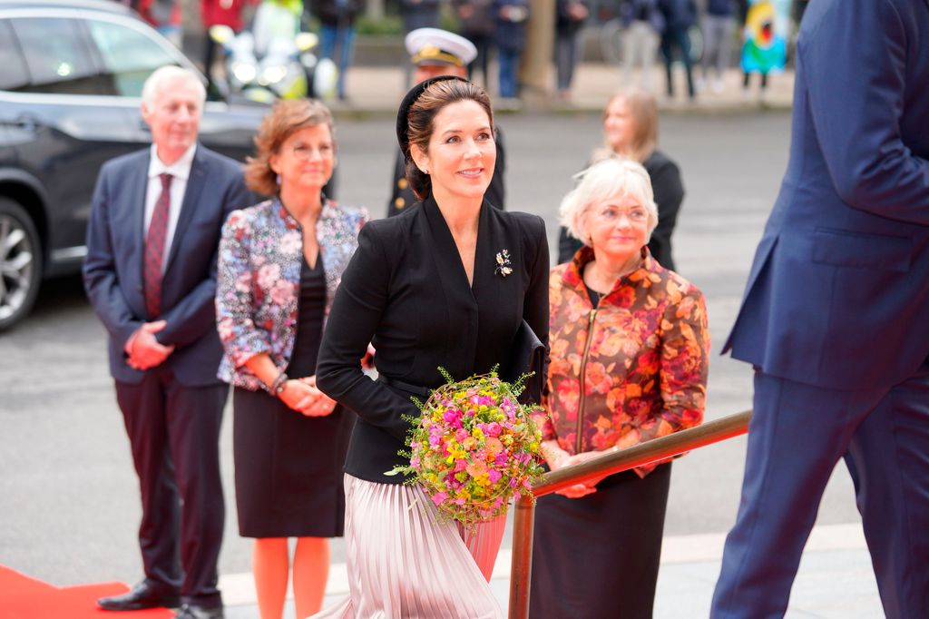 Mary smiling holding flowers