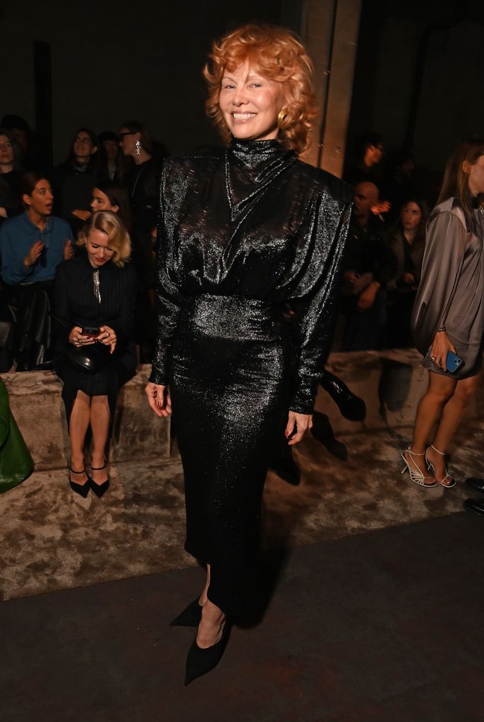 Pamela Anderson in black dress with red hair at the Mugler show during Paris Fashion Week 