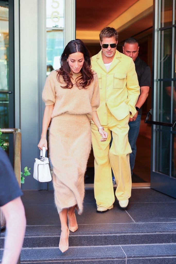 Brad Pitt looks stylish in a light yellow suit as he and Ines de Ramon depart from Fouquet's Hotel in New York during Fashion Week