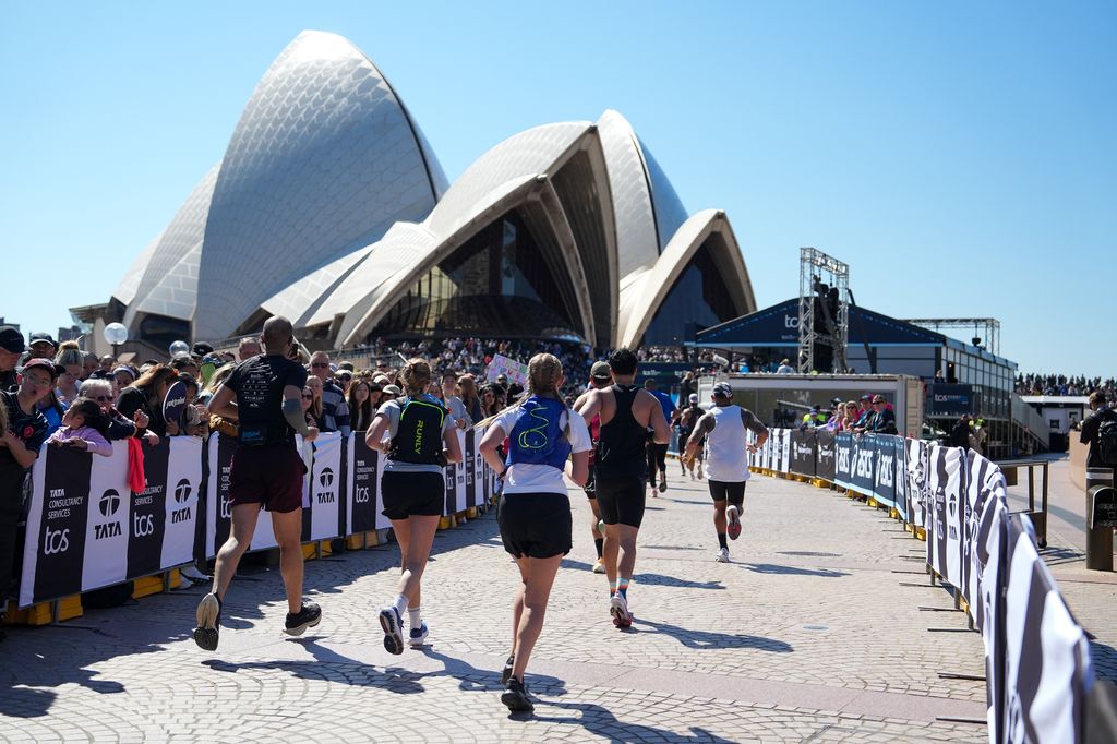 Runners pass by the Sydney Opera House