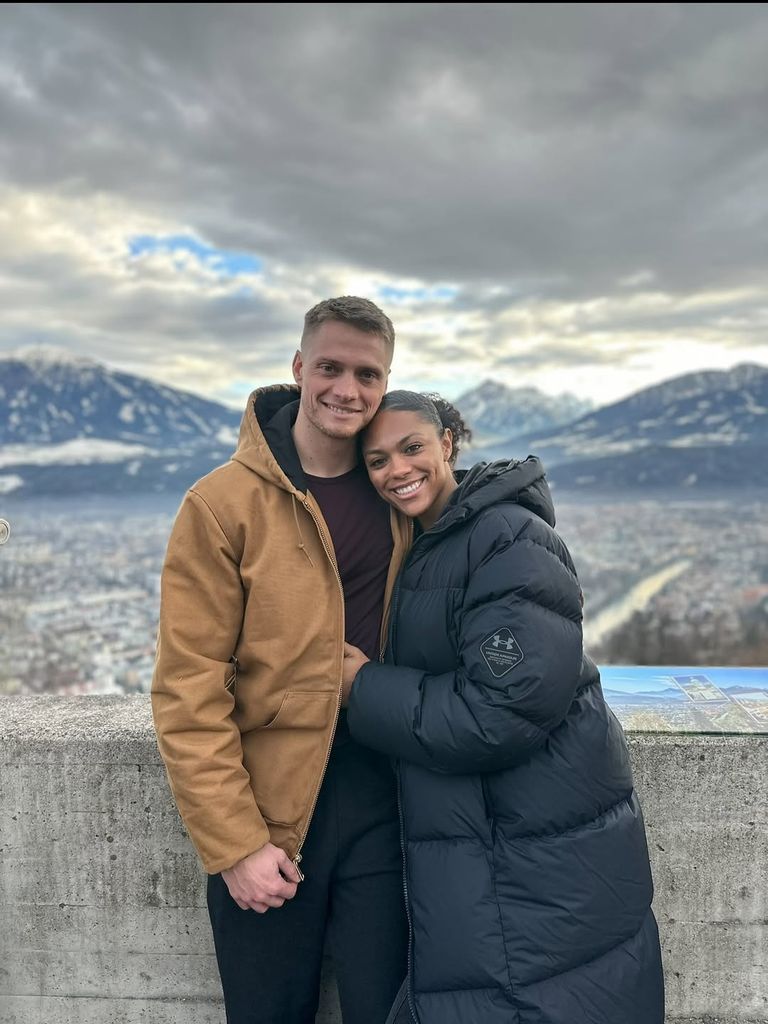 Hunter Powell et Kaysha Love sourient, les bras autour de l'autre, tous deux portant de gros manteaux