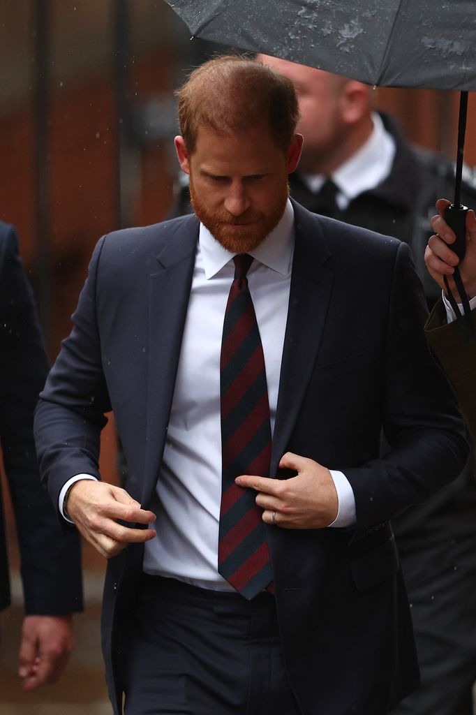 Prince Harry arriving at court under umbrella