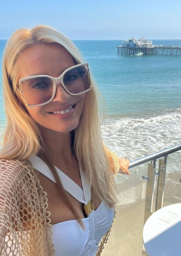 Tess Daly in a white outfit on a balcony