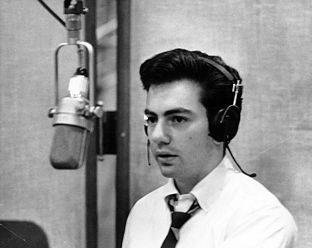 Singer Neil Diamond sings in to a microphone in the recording studio in 1963