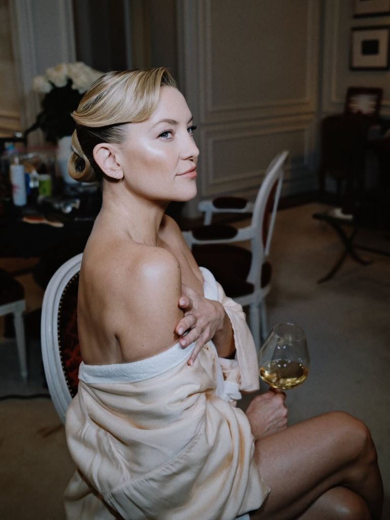 Kate Hudson in dressing robe holding glass of wine