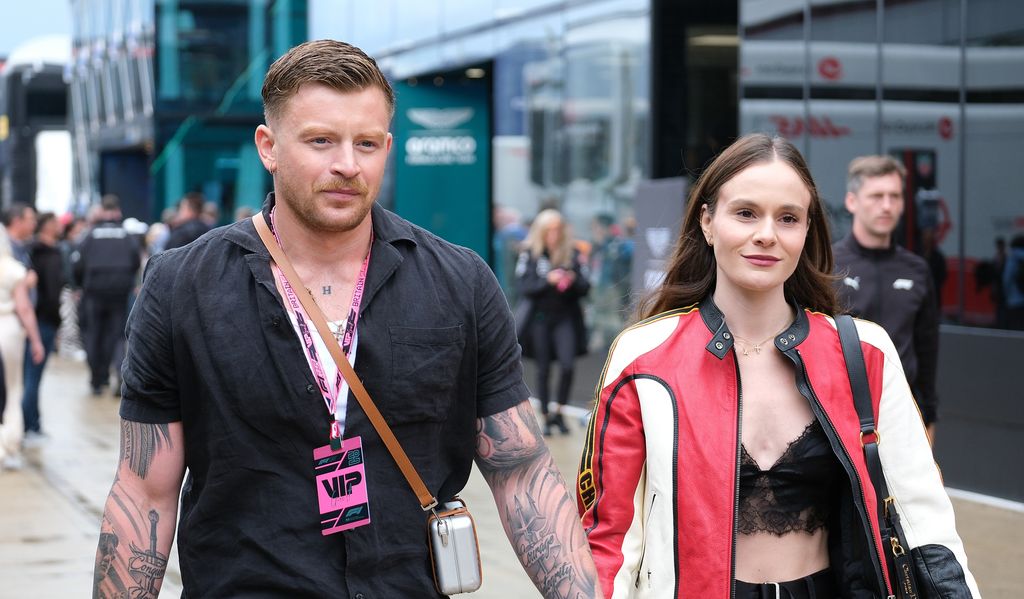 TOWCESTER, NORTHAMPTONSHIRE, UNITED KINGDOM - 2025/07/06: Olympic swimmer Adam Peaty and partner Holly Ramsay are seen in the paddock during the Formula One British Grand Prix at Silverstone. Lando Norris of McLaren Formula 1 Team wins the British Grand Prix. (Photo by Paul Bonser/SOPA Images/LightRocket via Getty Images)