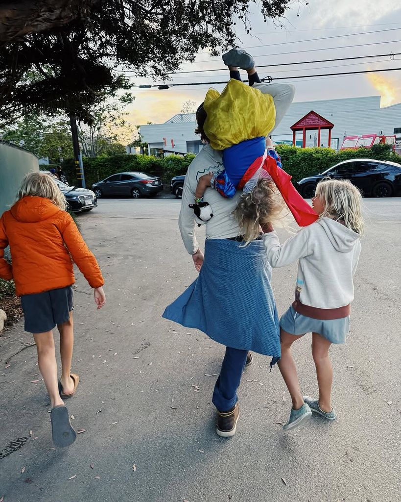Eric Christian Olsen walks with his three children, backs to the camera