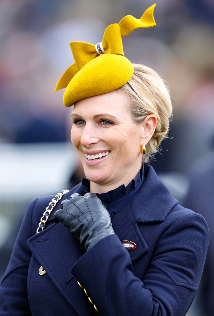 Zara Tindall in a navy coat and yellow fascinator