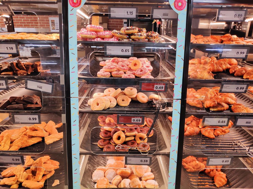 Fresh donuts and croissants in bakery aisle in Lidl store in Cork, Ireland.