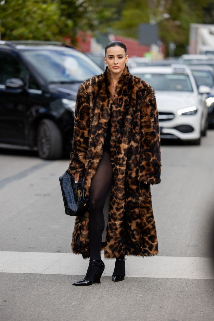 Livia Nunes Marques wears oversized tiger animal print faux fur coat, black bag, tights outside Ferragamo during the Milan Fashion Week - Womenswear Spring/Summer 2024 on September 23, 2023 in Milan, Italy. (Photo by Christian Vierig/Getty Images)