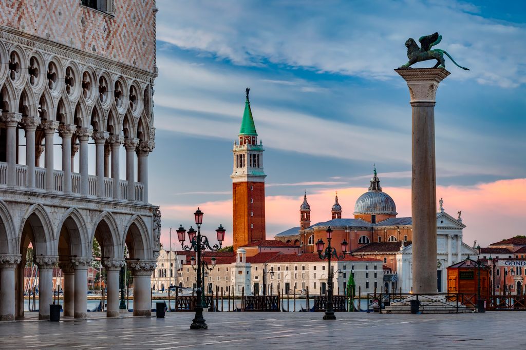 View from St Mark's Square to the church of San Giorgio Maggiore with the Doge's Palace (Palazzo Ducale) on the left. The winged lion of St Mark is the symbol of the city of Venice - Venice, Italy