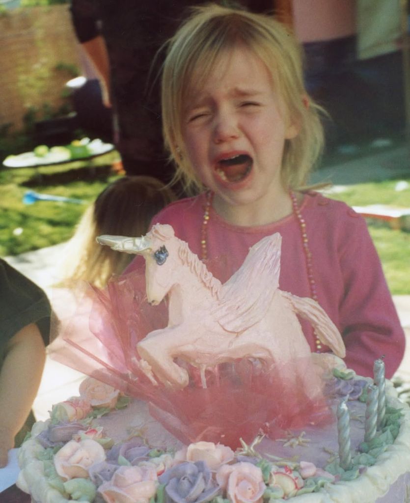 Billie Eilish as a child crying next to unicorn birthday cake