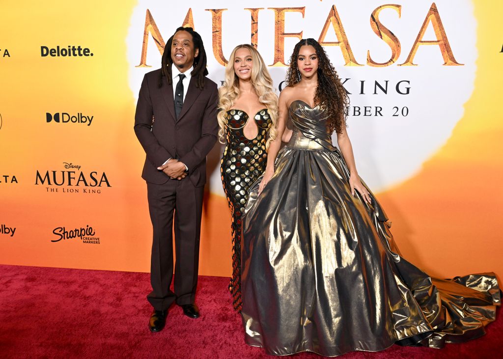 Jay-Z, Beyonce and Blue Ivy Carter standing together on the red carpet at the Mufasa Lion King