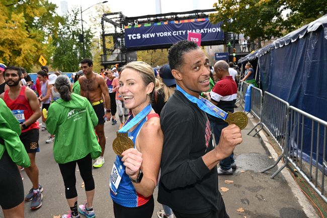 amy robach and tj holmes holding their marathon medals