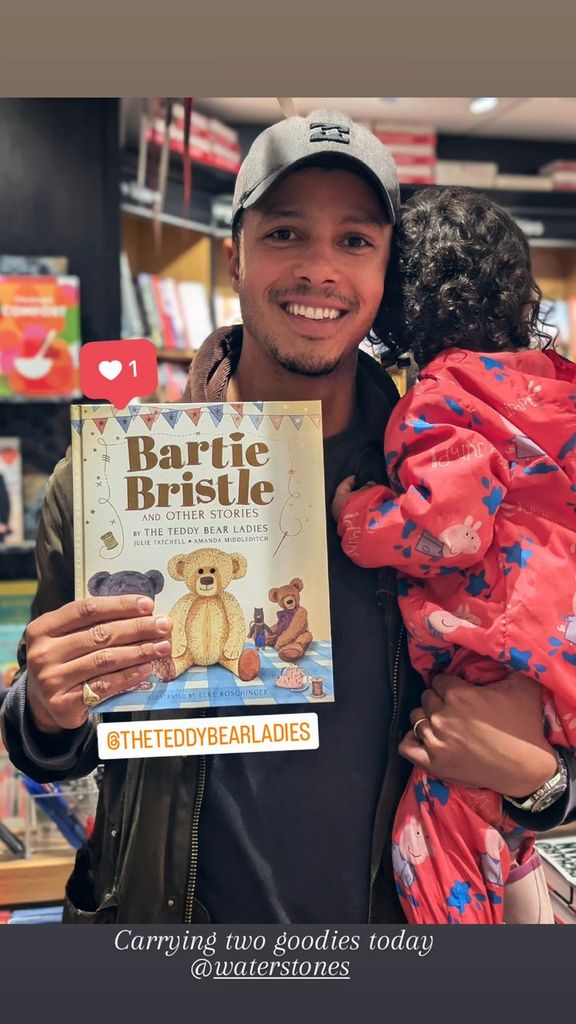 father posing with book and daughter