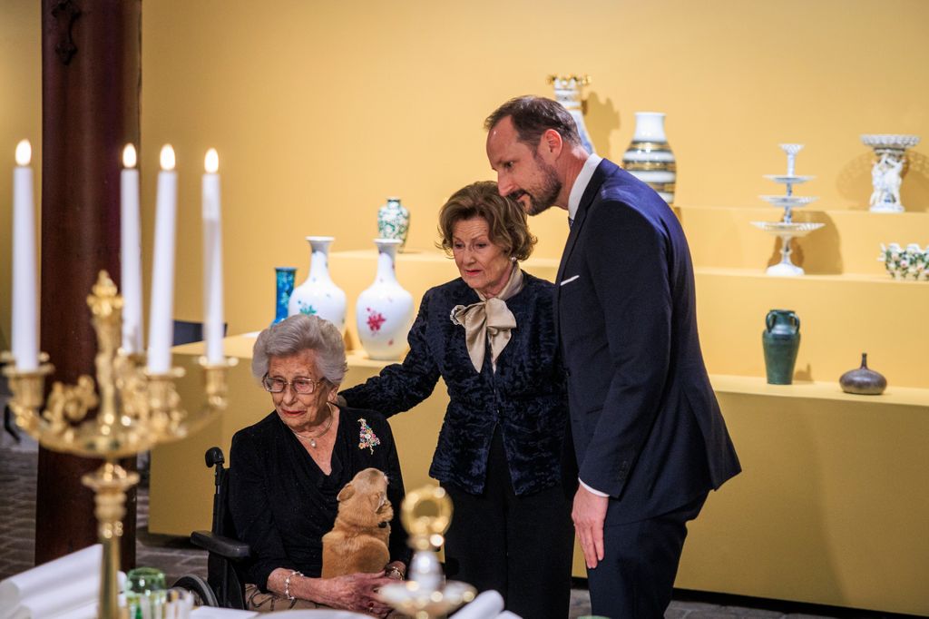 Princess Astrid, Queen Sonja and Crown Prince Haakon observing ceramics