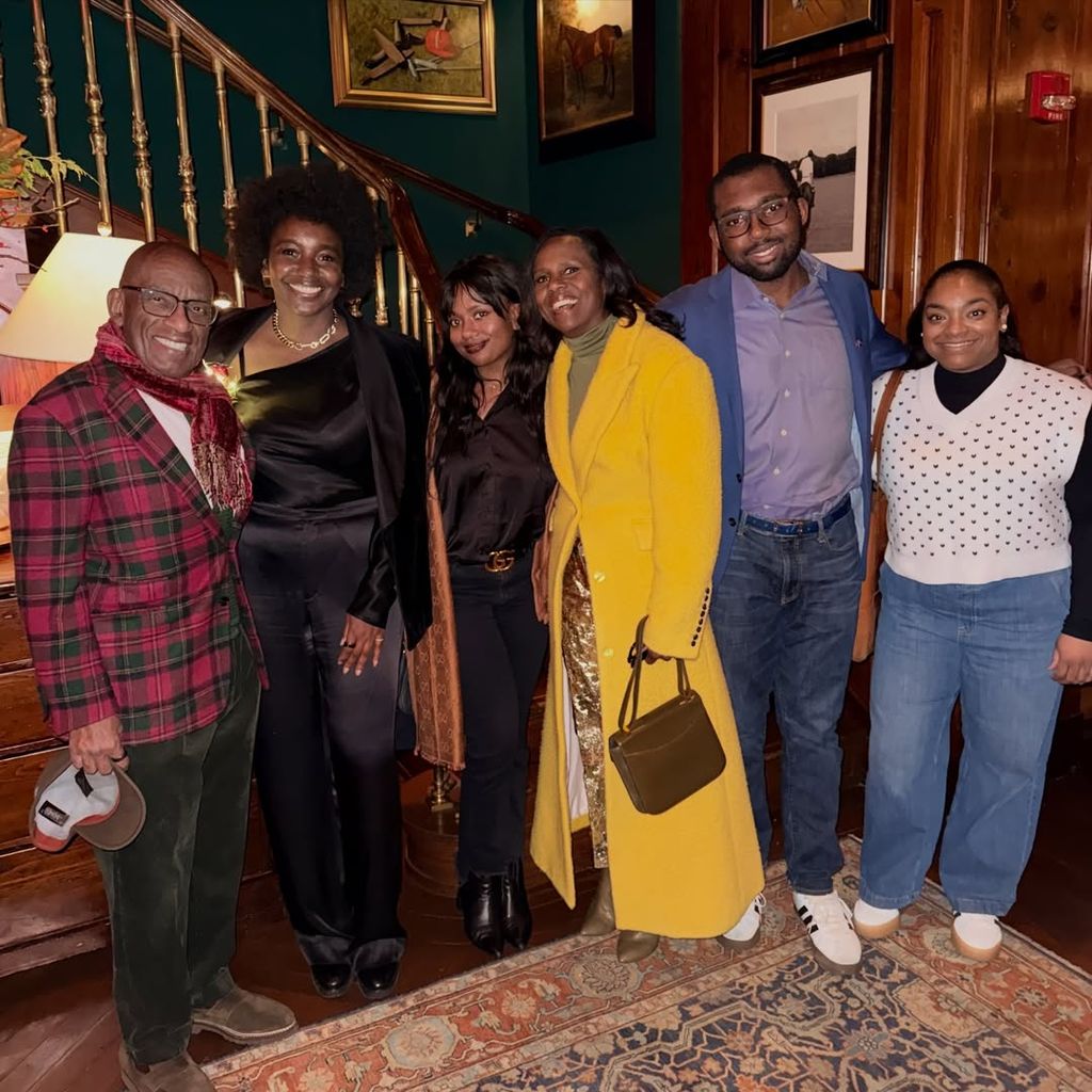Al Roker in red tartan jacket posing with his wife and kids