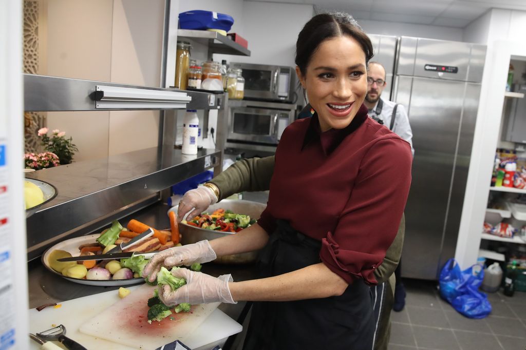 Meghan Markle chopping food in industrial cuisine