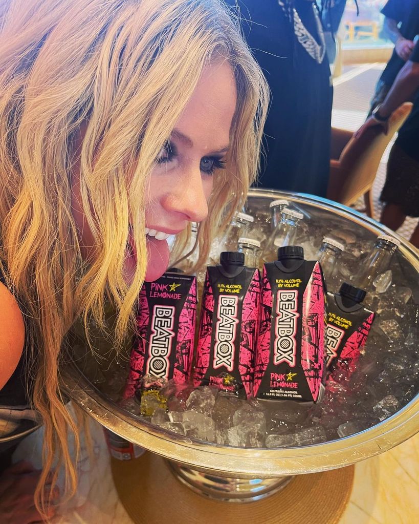 Avril Lavigne sticks her tongue out over an ice bucket of BeatBox juice