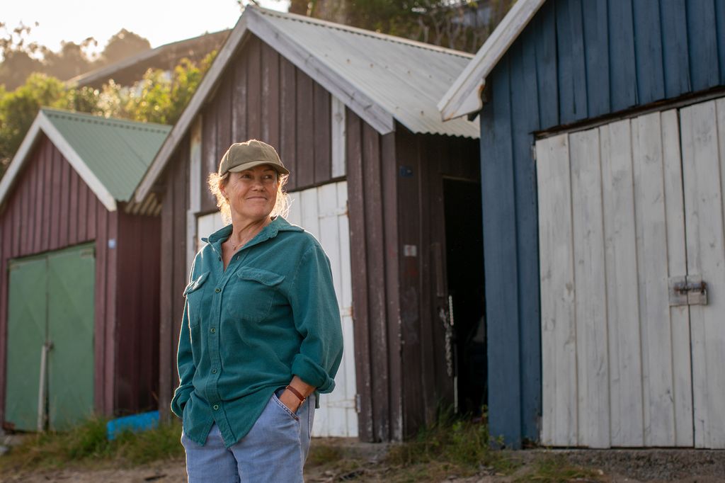 woman wearing cap standing in front of beach huts