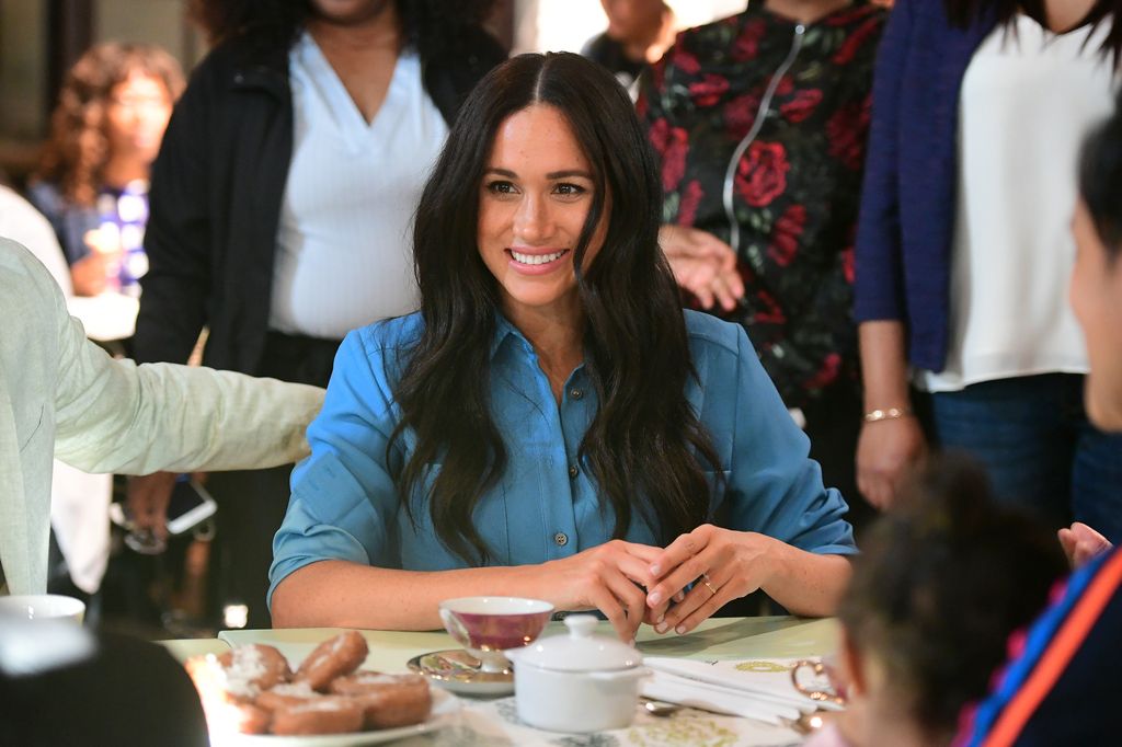 Meghan Markle wearing blue dress and smiling