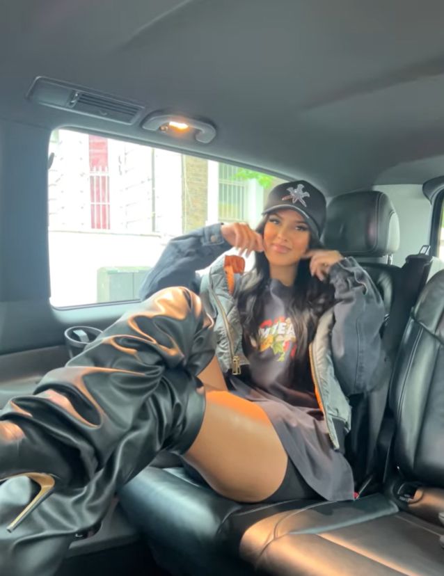 Maya Jama in back of car in shorts