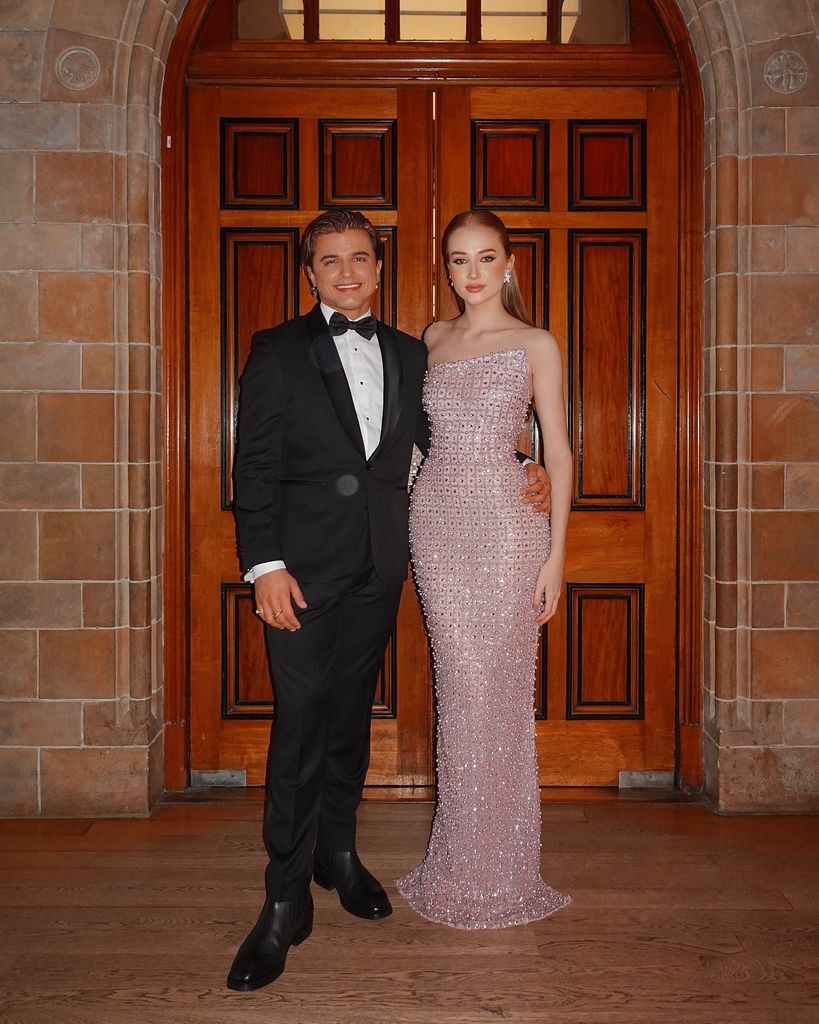 couple posing in front of wooden doors