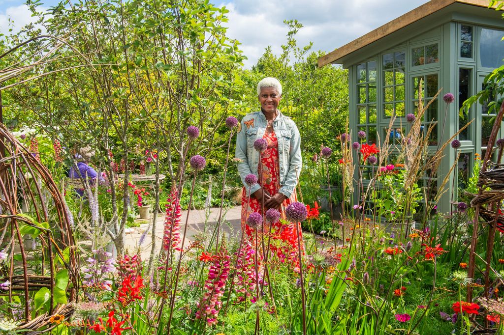 Arit Anderson in a denim jacket in a garden