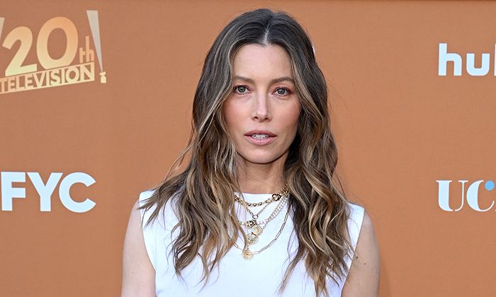 Jessica Biel wearing white and sporting tousled, blonde-tinted hair poses for the camera.