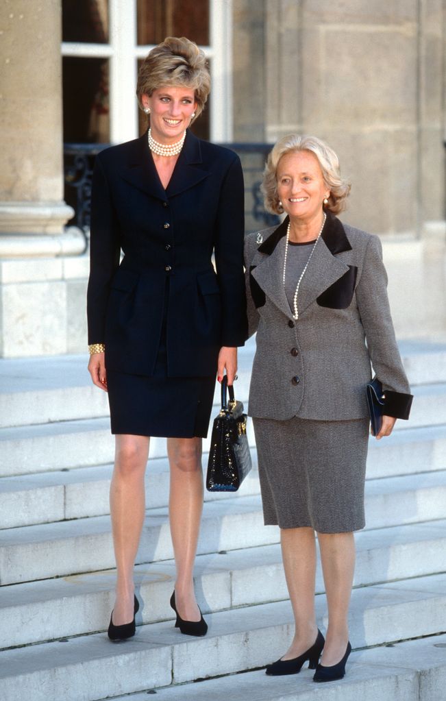  Diana, Princess of Wales, wearing a black suit and holding a black crocodile skin handbag designed by Versace, poses with French First Lady Bernadette Chirac on the steps of the Elysee Palace on September 25, 1995 in Paris, France
