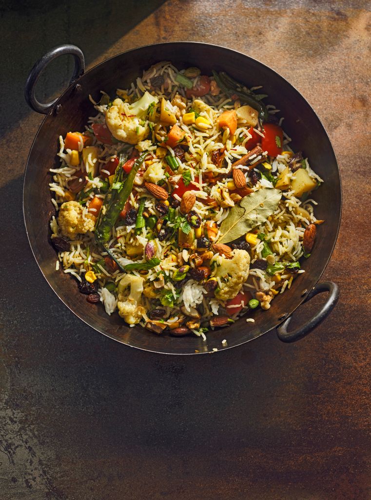 A wok filled with rice and vegetables 