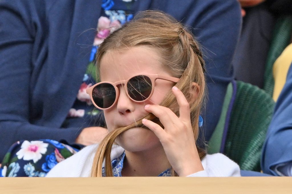 Princess Charlotte wearing sunglasses with her hair in her mouth