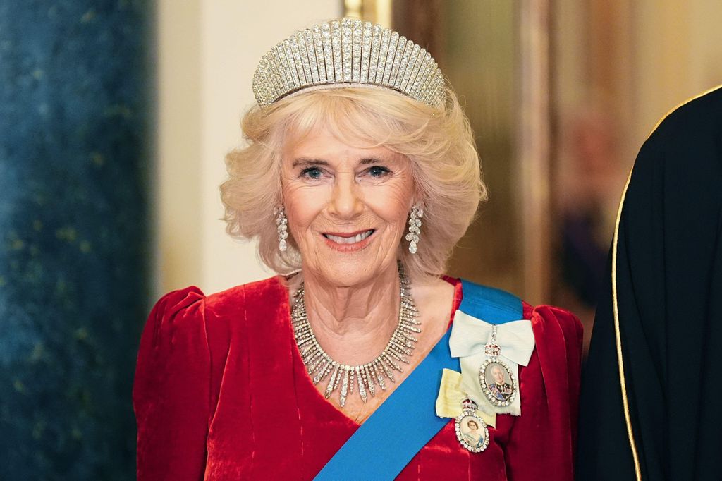 Queen Camilla wearing red dress and tiara