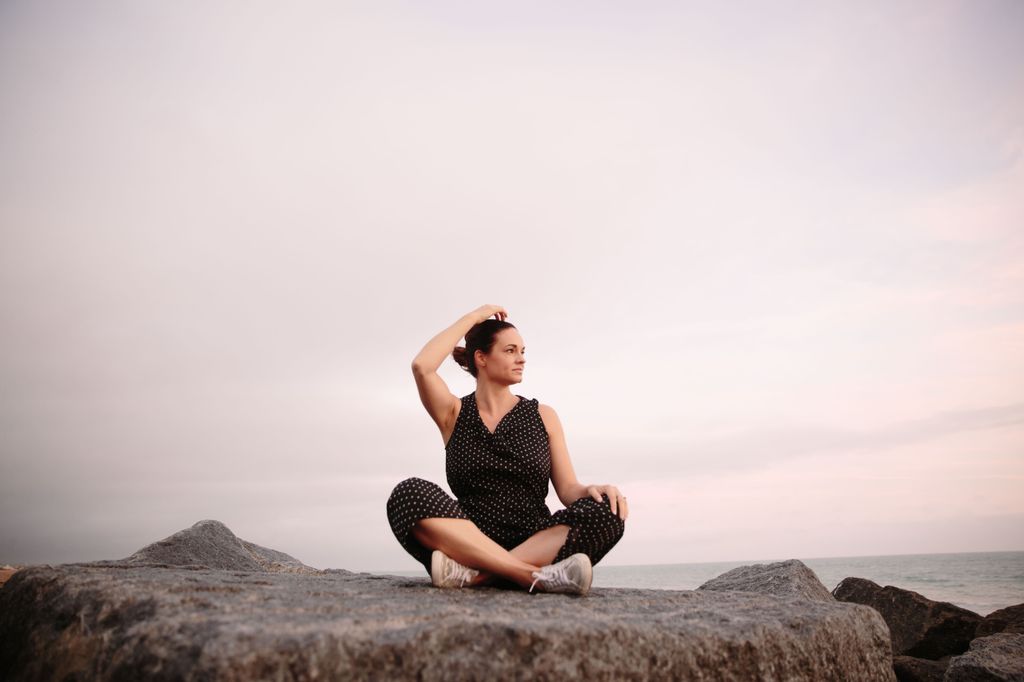 Sarah sat on a rock on the beach, doing some EFT