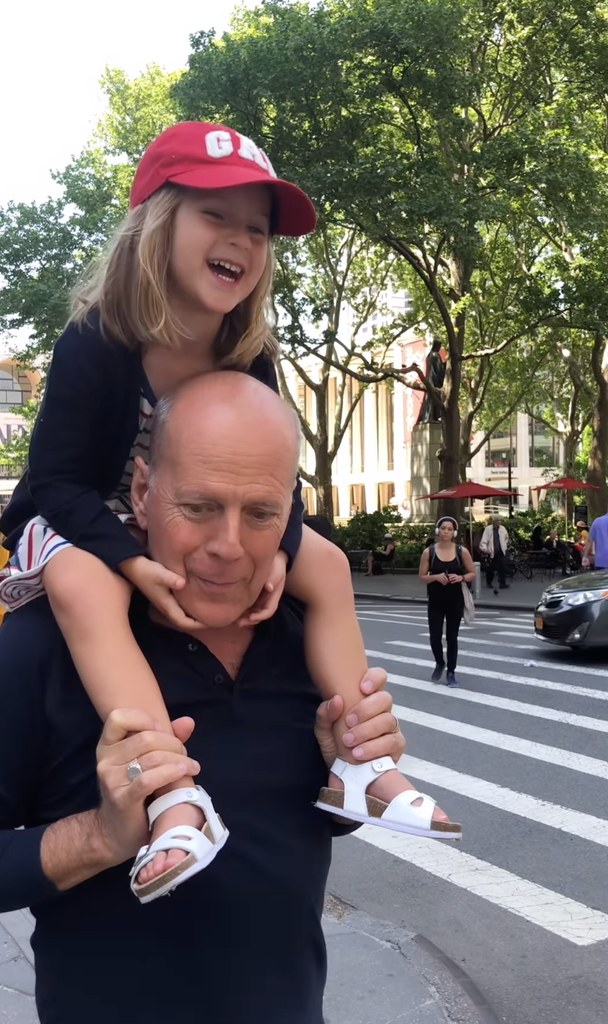 Still from a throwback video shared by Bruce Willis' wife Emma Heming in which he is walking around New York City with his daughter Evelyn sitting on his shoulders