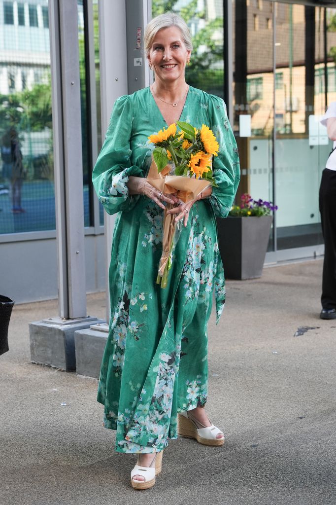 The Duchess of Edinburgh smiles in green dress holding sunflowers