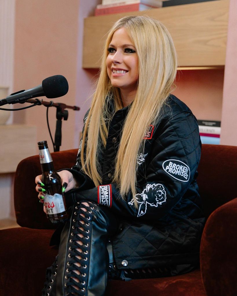 Avril Lavigne on the call her daddy podcast smiling with a beer