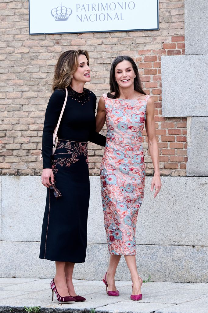 Laughing Queen Rania and Queen Letizia put their hands around each other