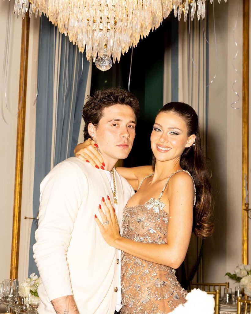 Nicola Peltz posing with Brooklyn Beckham and wearing a dress with glitzy bows 