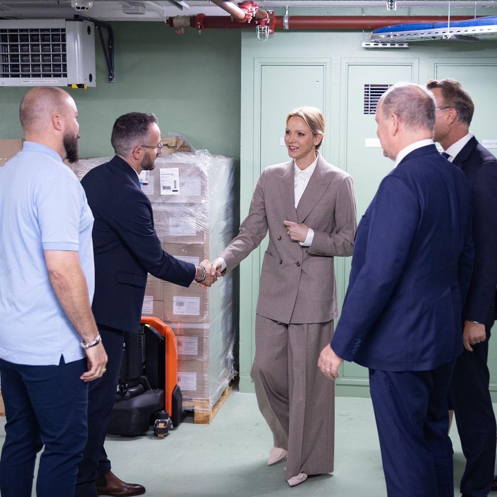 Princess Charlene in suit shaking hand of man