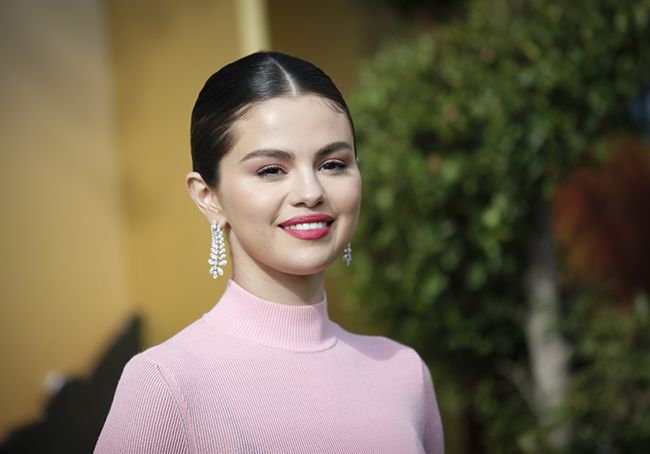 Selena Gomez smiling in pink dress