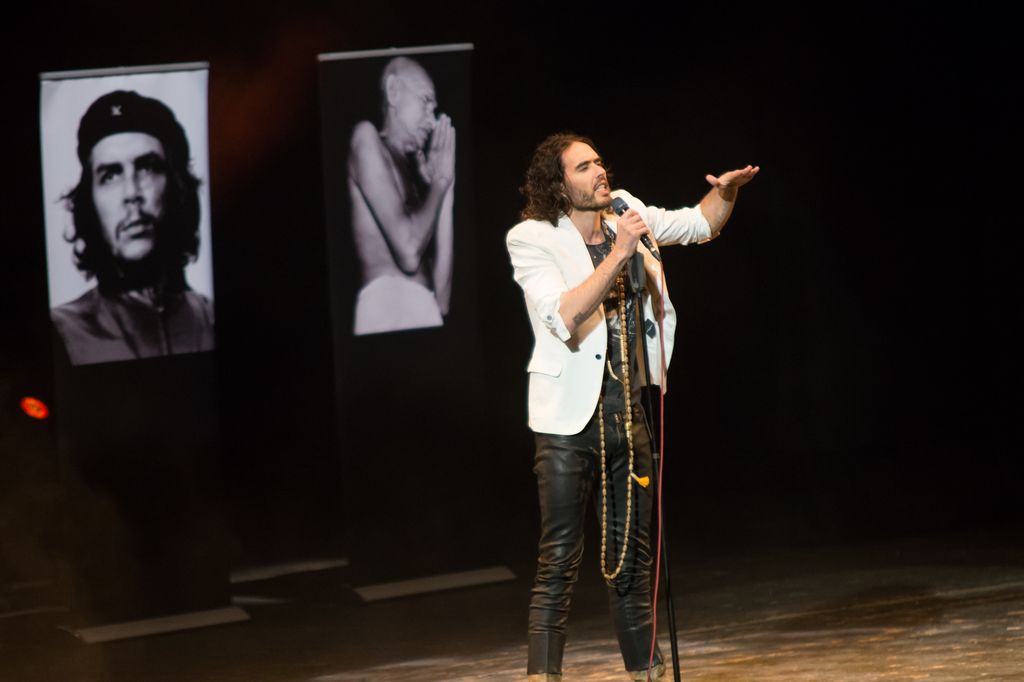 Russell Brand performing with a microphone
