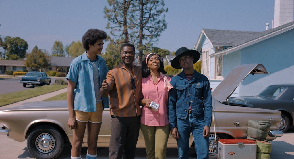family standing in front of car in sunny street
