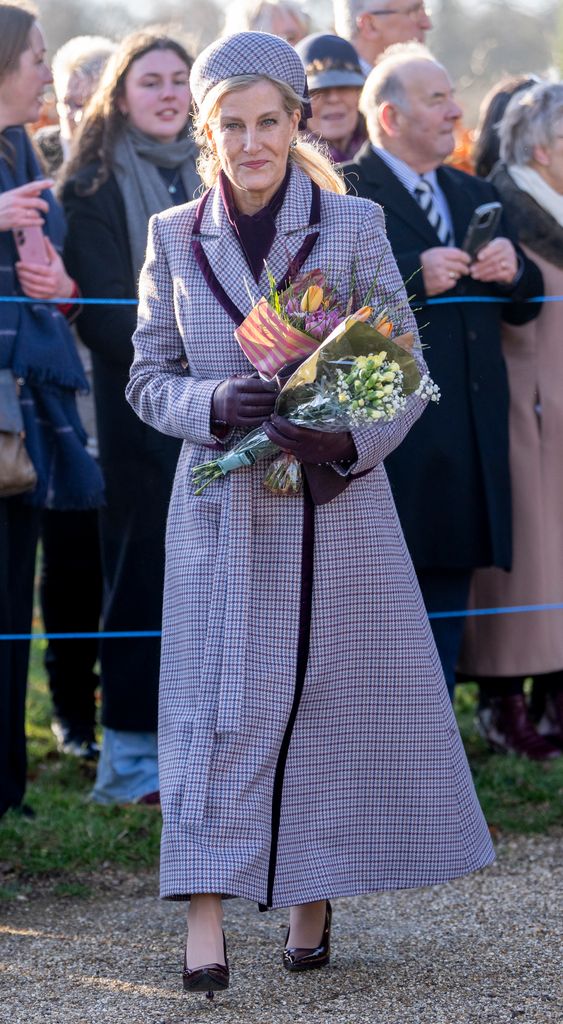 Sophie, Duchess of Edinburgh in houndstooth coat holding flowers
