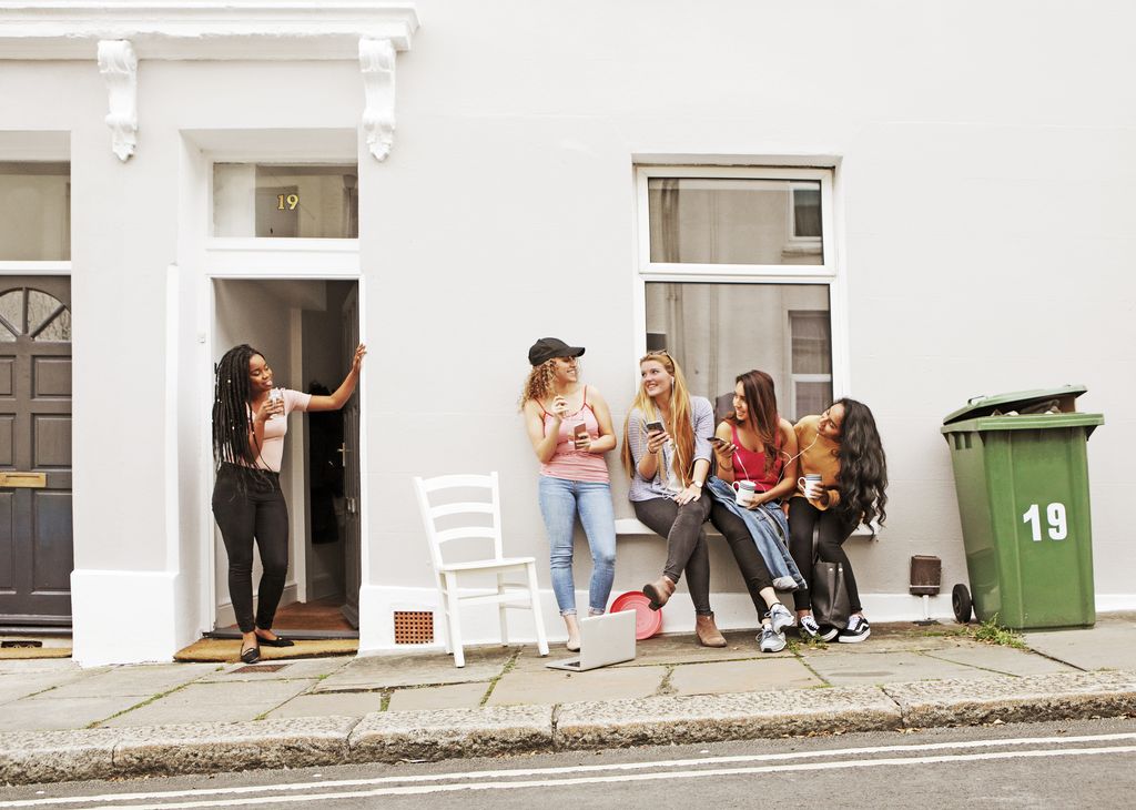 Students relaxing outside house