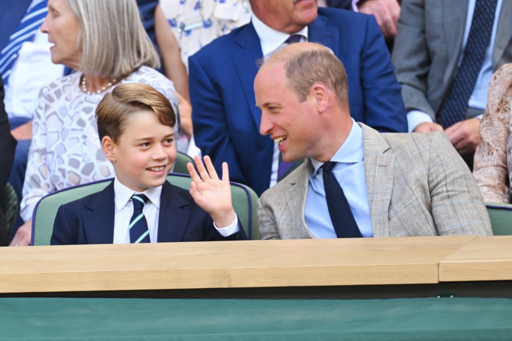 Prince George and Prince William smiling at tennis