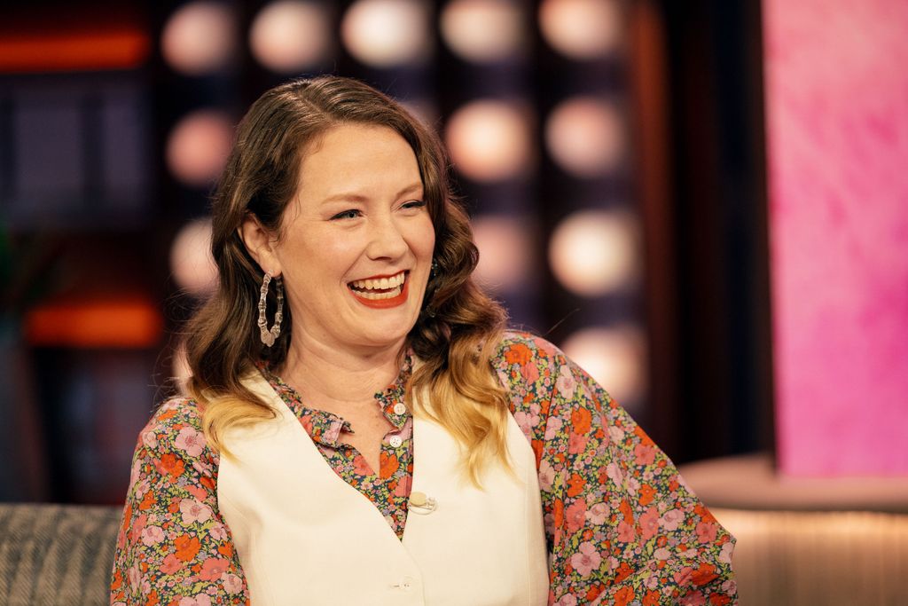 EA Hanks sits on a sofa